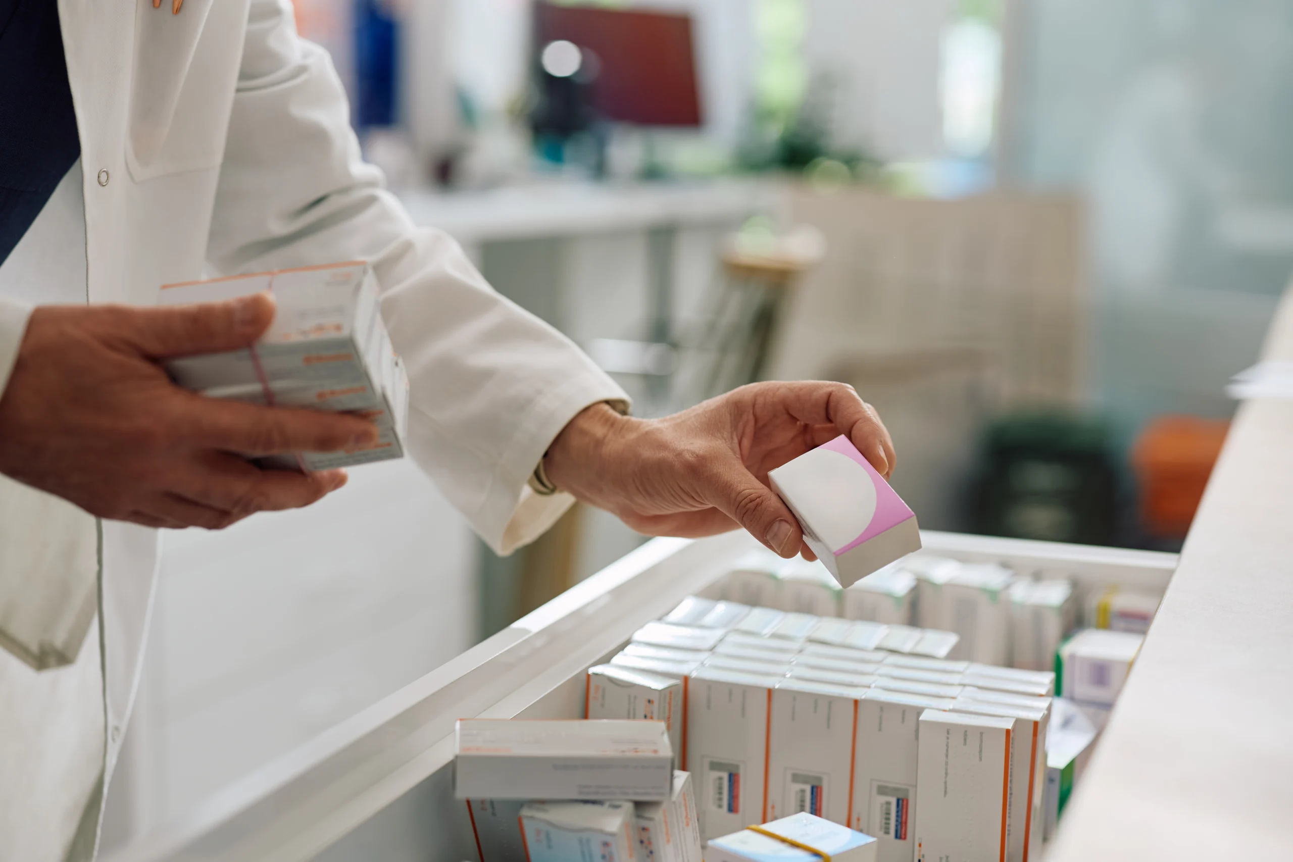 Close up of pharmacist checking medicine supplies at drugstore.